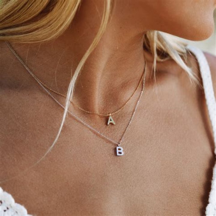 An initial necklace, a toiletry bag, a face shield and bestselling candles